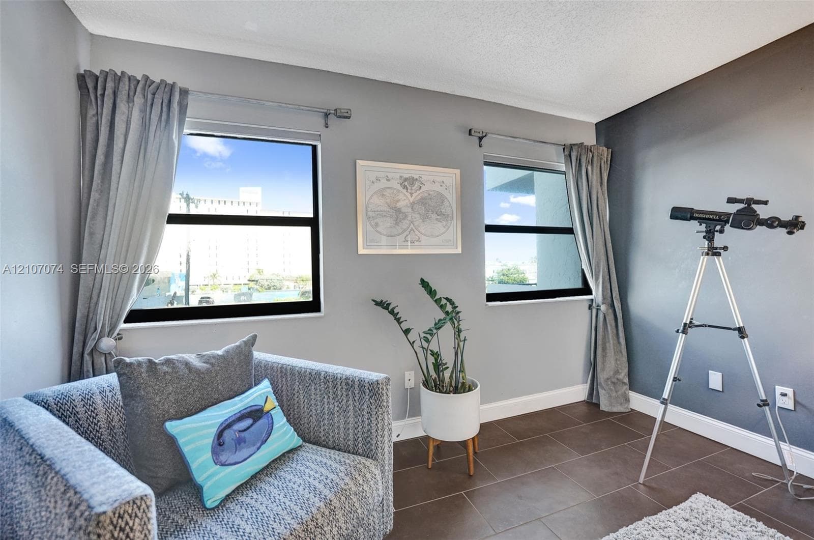 Interior space featuring dual windows with black frames, tile flooring, and a contrast wall with a matte finish