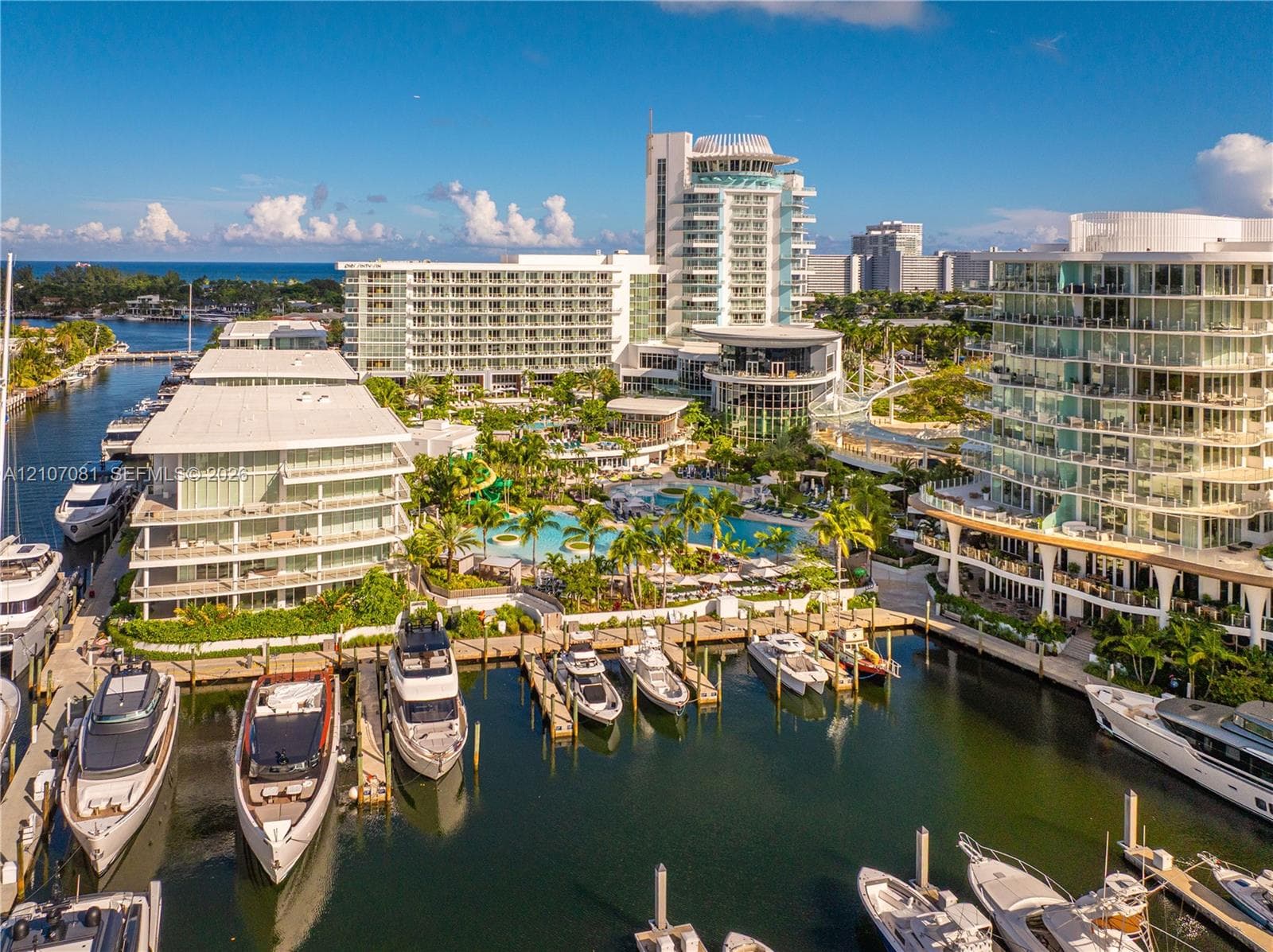 Waterfront complex featuring deep-water boat slips, a swimming pool, and tropical landscaping