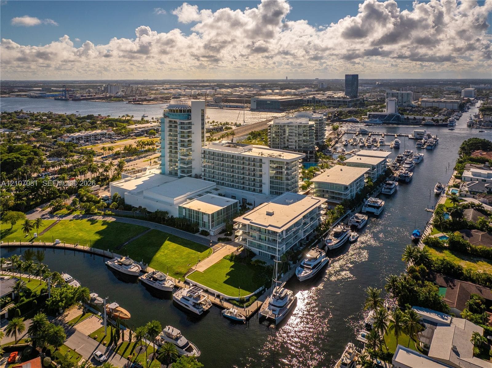 Aerial perspective of a multi-structure complex featuring deep-water canal access, private boat slips, extensive manicured lawn areas, and proximity to coastal waterways