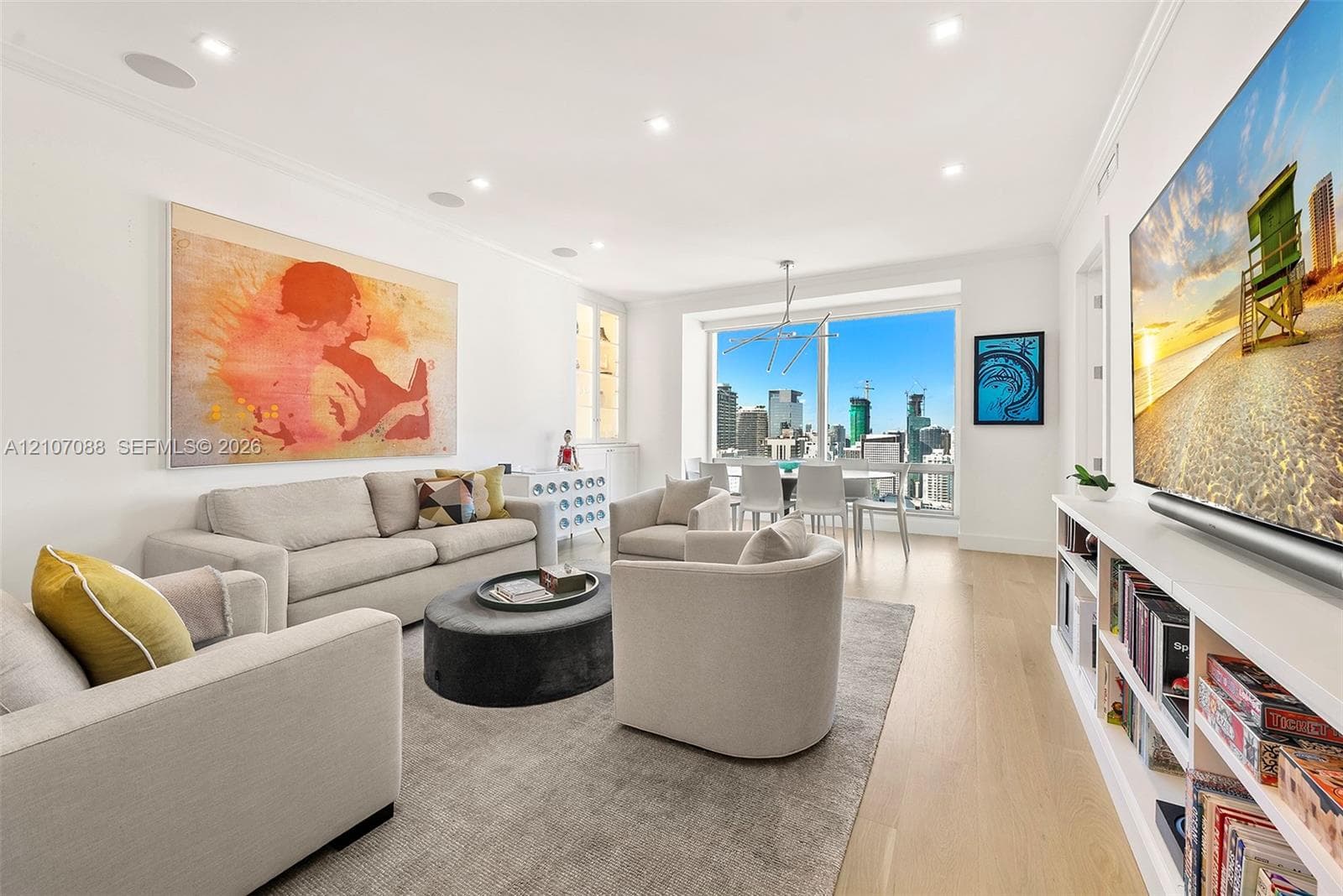 Living space featuring white-oak engineered wood flooring, recessed lighting, integrated ceiling speakers, built-in shelving, and floor-to-ceiling windows.