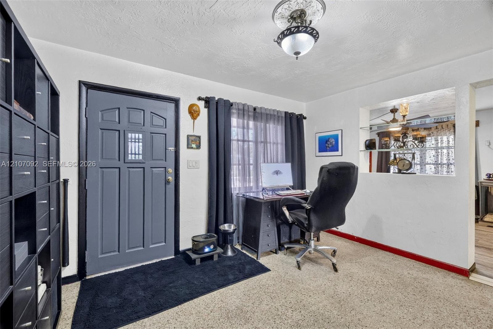 Entryway featuring a multi-panel door with inset glass, decorative ceiling medallion with pendant lighting, and a recessed wall niche with glass shelving