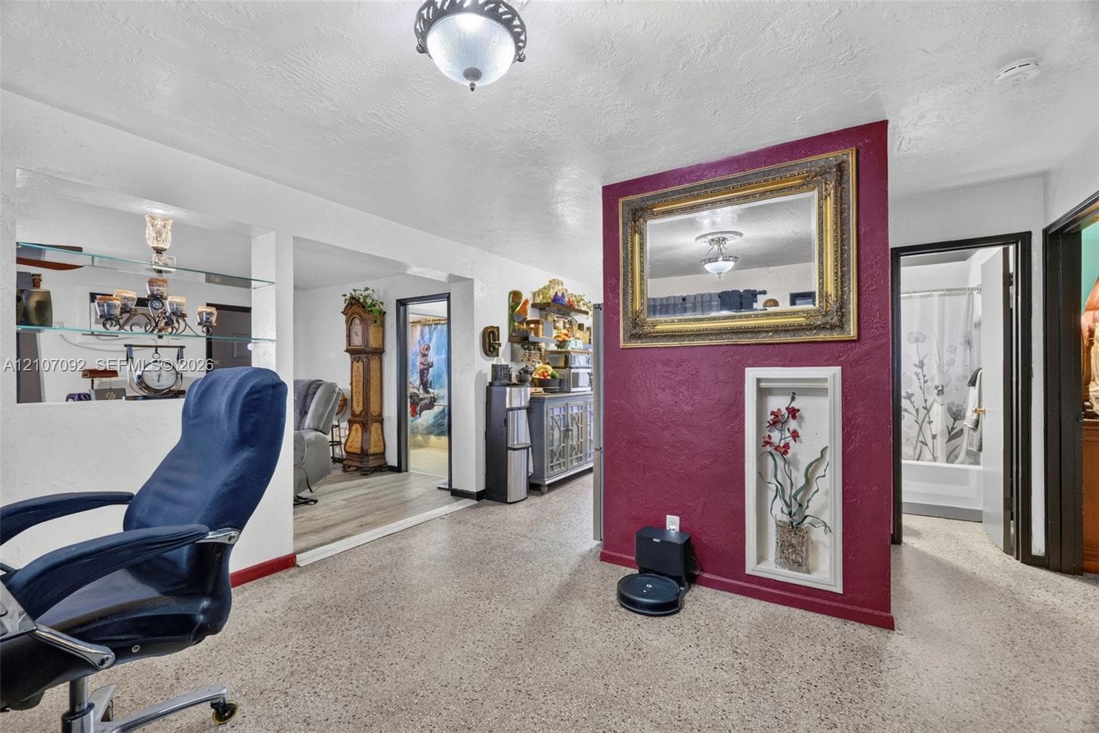 Interior space featuring terrazzo flooring, a built-in recessed wall niche, a decorative accent wall, and glass display shelving