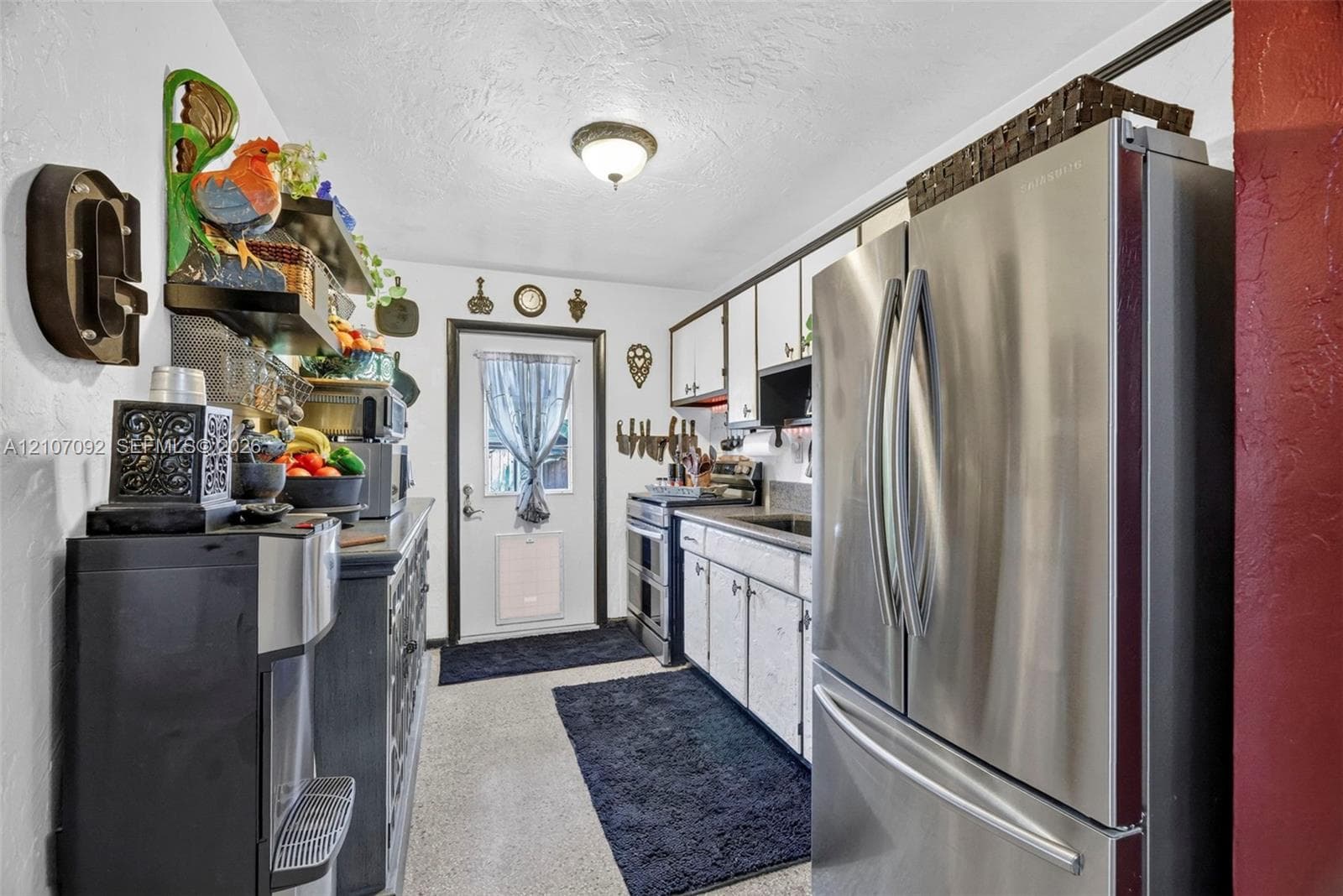 Kitchen featuring white cabinetry, stainless steel French-door refrigerator, integrated range, and flush-mount ceiling lighting
