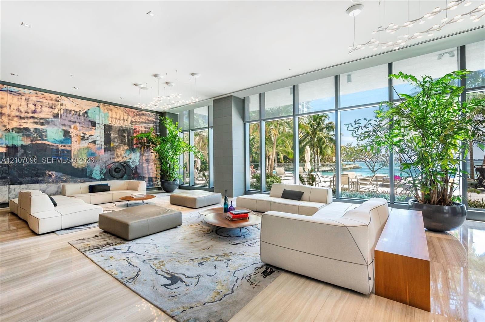 Floor-to-ceiling glass windows, polished stone flooring, recessed lighting, architectural wall-mounted lighting fixtures, and large-scale decorative wall installation