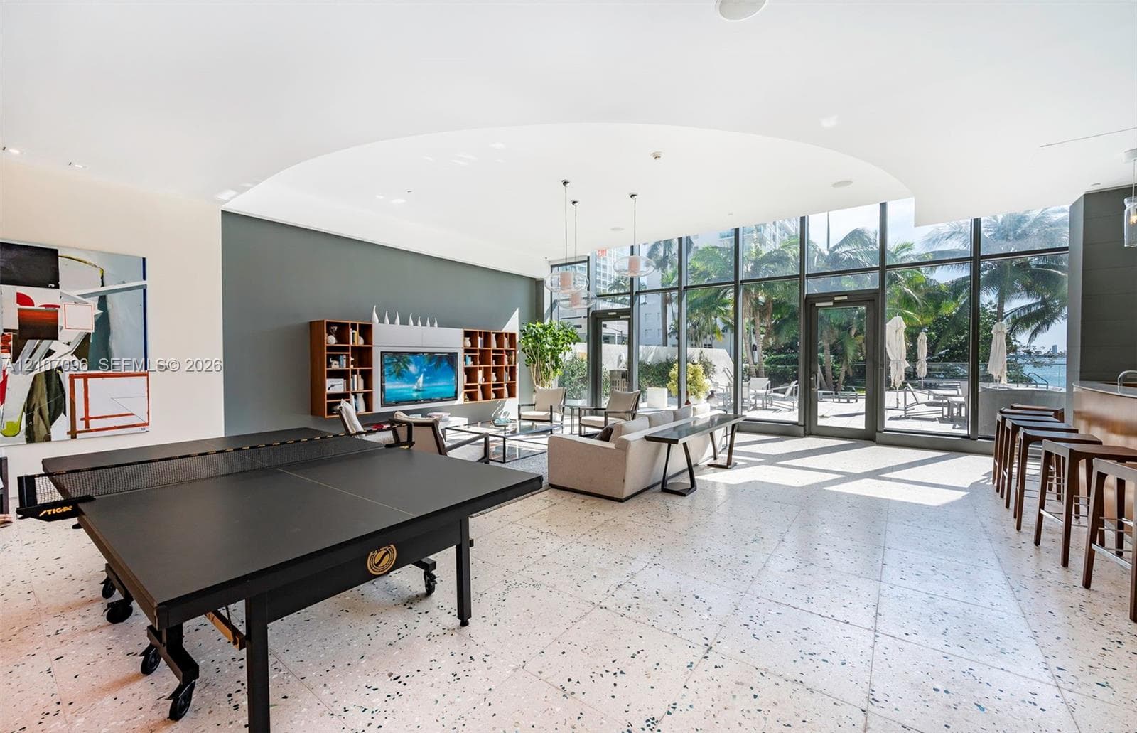 Open-concept space featuring floor-to-ceiling windows, terrazzo flooring, built-in wooden shelving, and recessed lighting