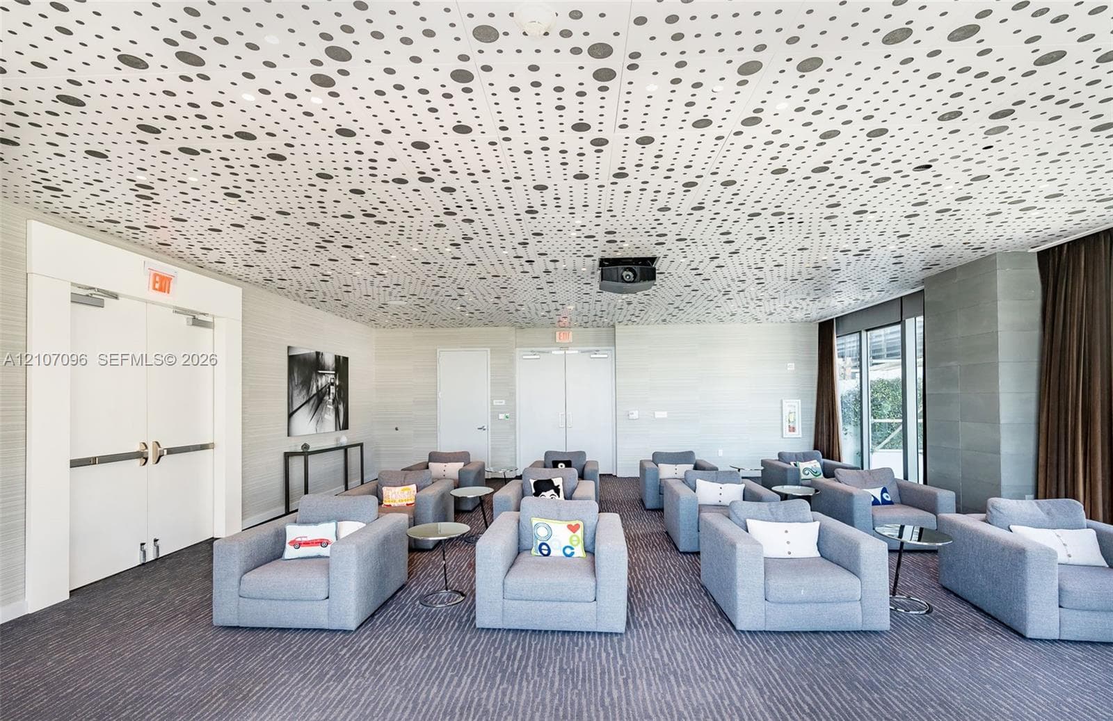 Custom patterned acoustic ceiling tiles, neutral wall textures, and double-door entry