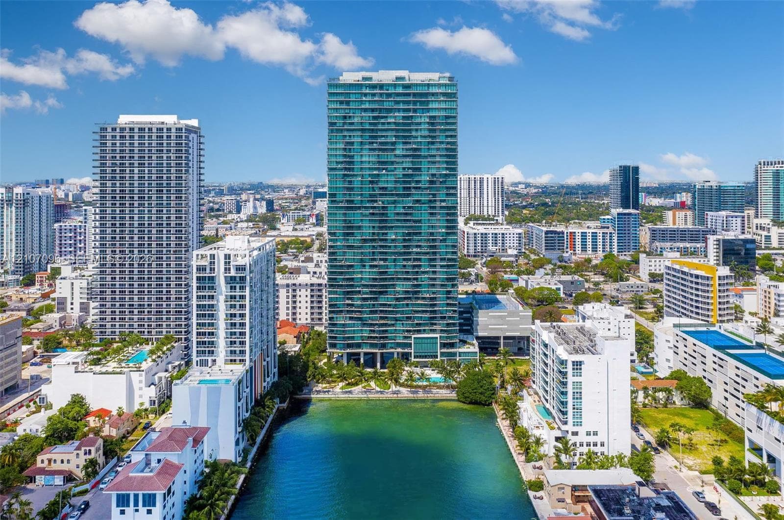 High-rise building featuring a glass facade, private balconies, and waterfront positioning
