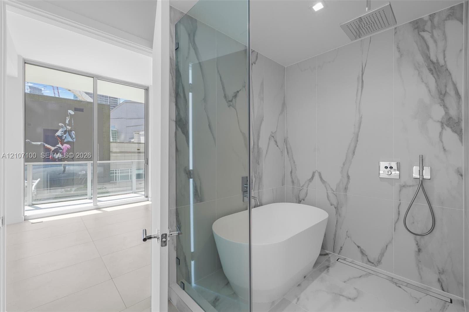 Double vanity featuring wood-finish cabinetry, solid-surface countertops with integrated rectangular sinks, integrated vertical mirror lighting, and floor-to-ceiling large-format stone-patterned tiling