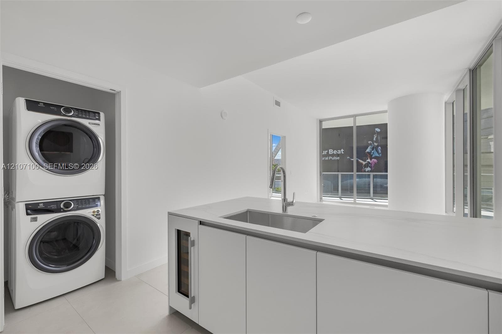 Modern kitchen featuring white flat-panel cabinetry, wood-finish upper cabinets, integrated appliances, stone-surface backsplash, and built-in wall oven