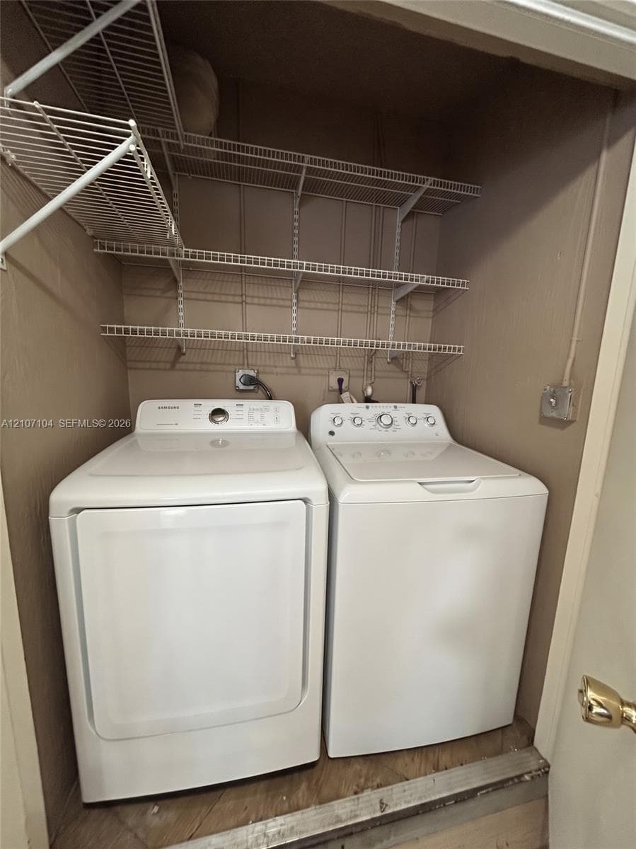 Laundry closet featuring three tiers of wire shelving and dedicated utility connections