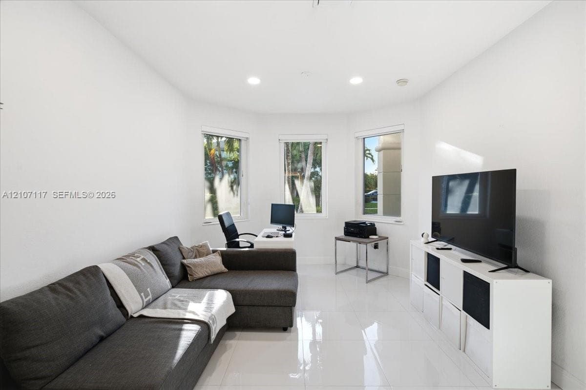 Bright room featuring glossy tile flooring, three large windows, and recessed lighting