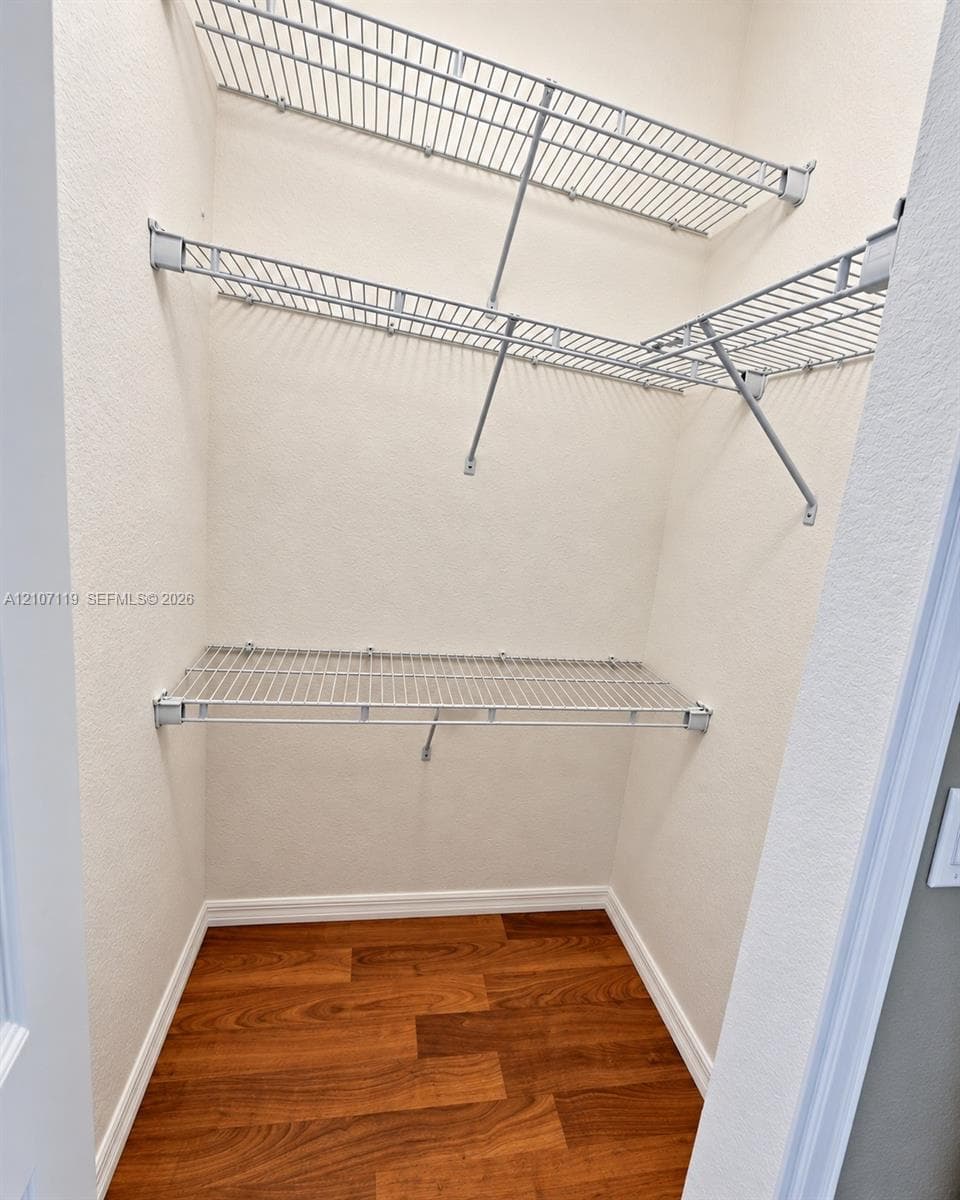 Storage area featuring wood-finish flooring and tiered metal shelving