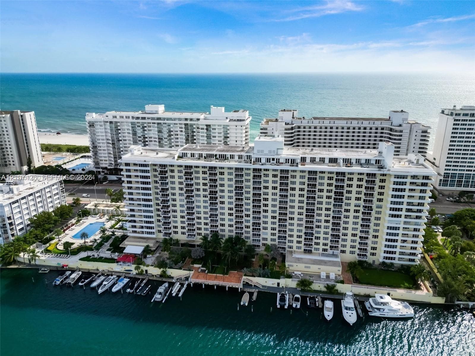 High-rise residential complex featuring waterfront bulkhead, private boat slips, swimming pool, and proximity to coastal shoreline