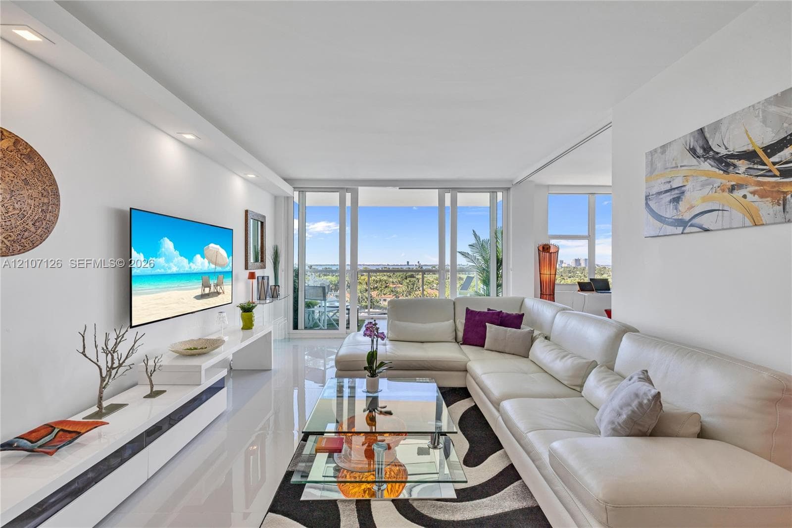 Living area featuring polished tile flooring, recessed ceiling lighting, a built-in media console, and floor-to-ceiling glass sliding doors