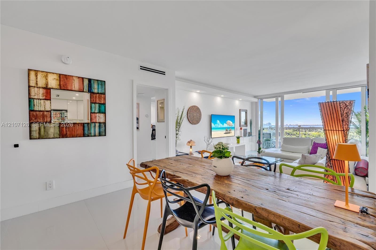 Open-concept living space featuring high-gloss tile flooring, recessed ceiling lighting, and floor-to-ceiling glass panel doors