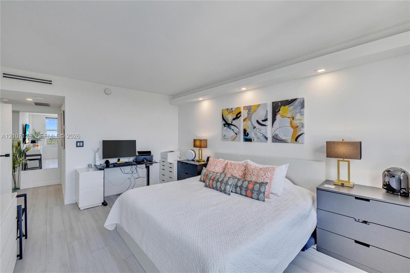 Light-toned wood-finish flooring, recessed ceiling lighting, and a prominent architectural bulkhead feature