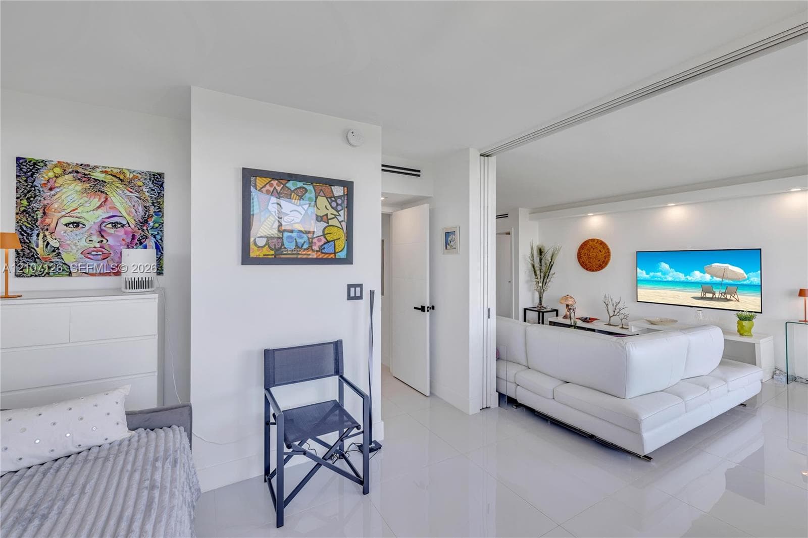 Polished white tile flooring, recessed ceiling lighting, and sliding track doors