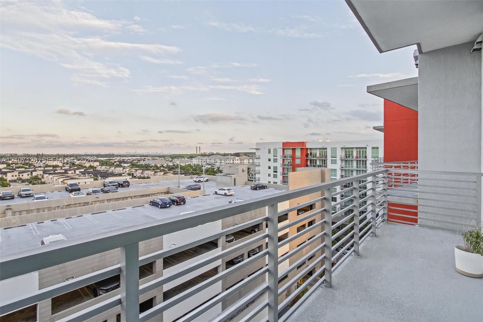 Private balcony featuring a concrete floor and a horizontal metal rail system