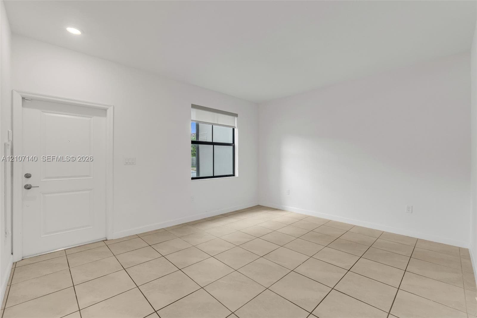 Neutral-toned ceramic tile flooring, recessed ceiling lighting, and a single-panel interior door