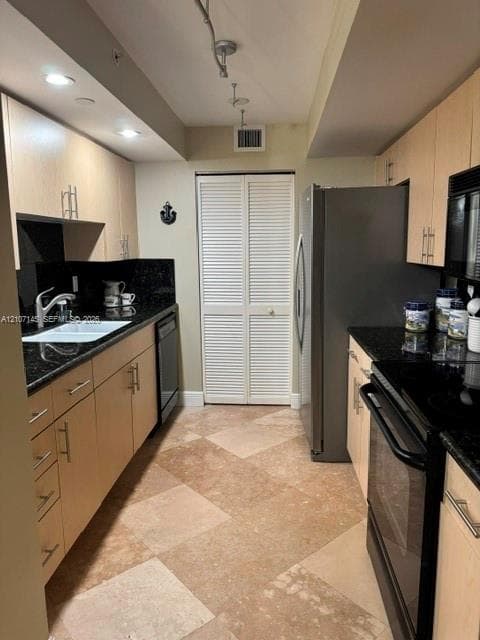 Kitchen featuring light-finish cabinetry, dark stone countertops, tile flooring, stainless steel appliances, and track lighting