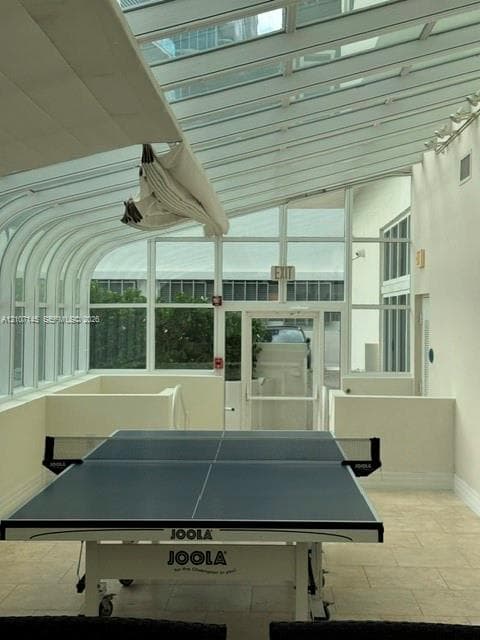 Sunroom featuring a curved glass roof, floor-to-ceiling windows, and tile flooring