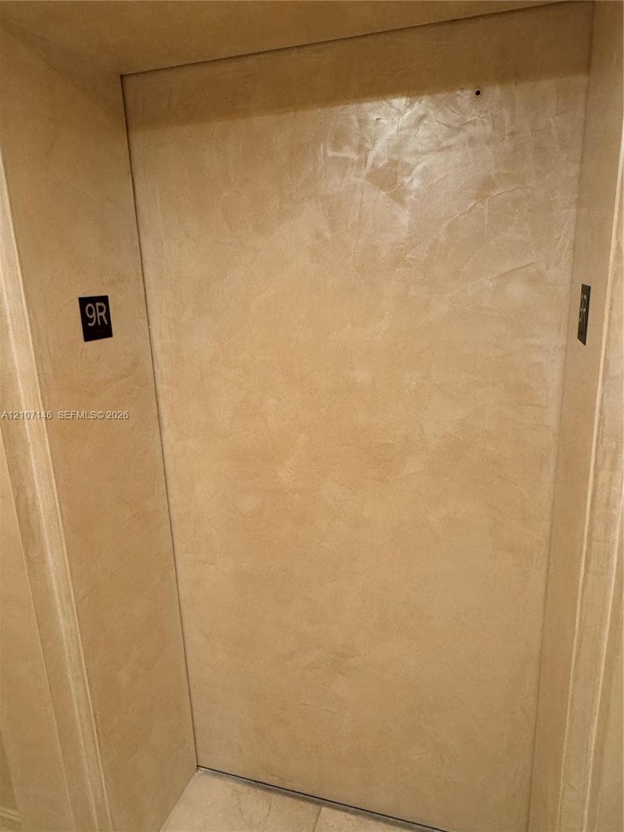Floor-to-ceiling glass sliding doors with drapery, wood-finish flooring, and crown molding