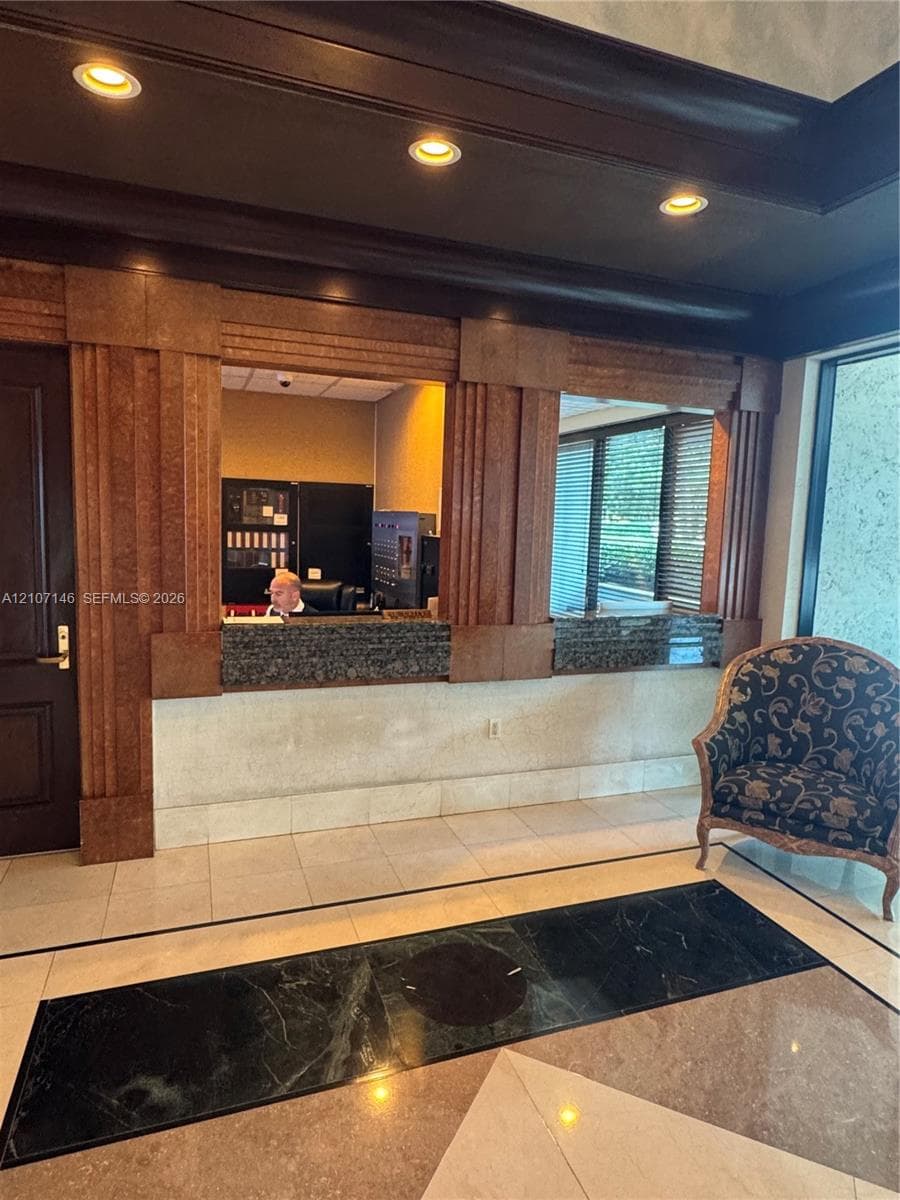 Walk-in shower enclosure featuring floor-to-ceiling tile, frameless glass door, metallic hardware, and wall-mounted shower fixture