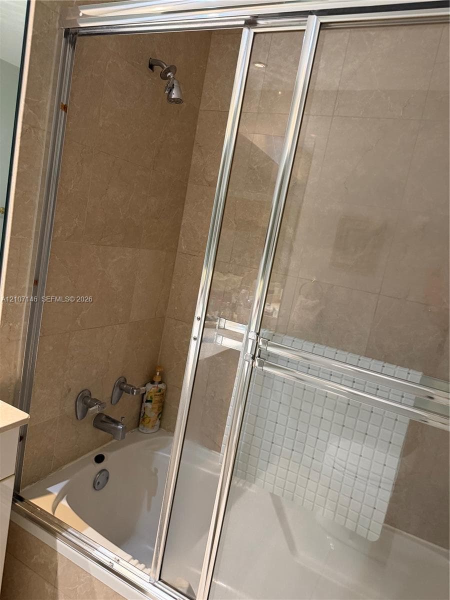Large-format stone tile flooring, floor-to-ceiling glass sliding doors, and crown molding