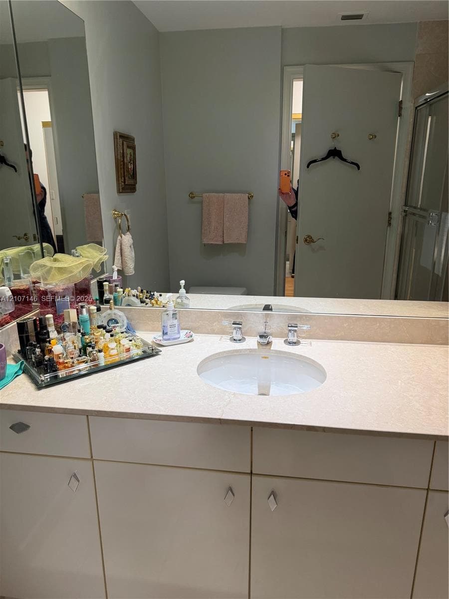 Floor-to-ceiling dark wood built-in cabinetry featuring extensive open shelving, integrated desk surface, recessed task lighting, and central media enclosure