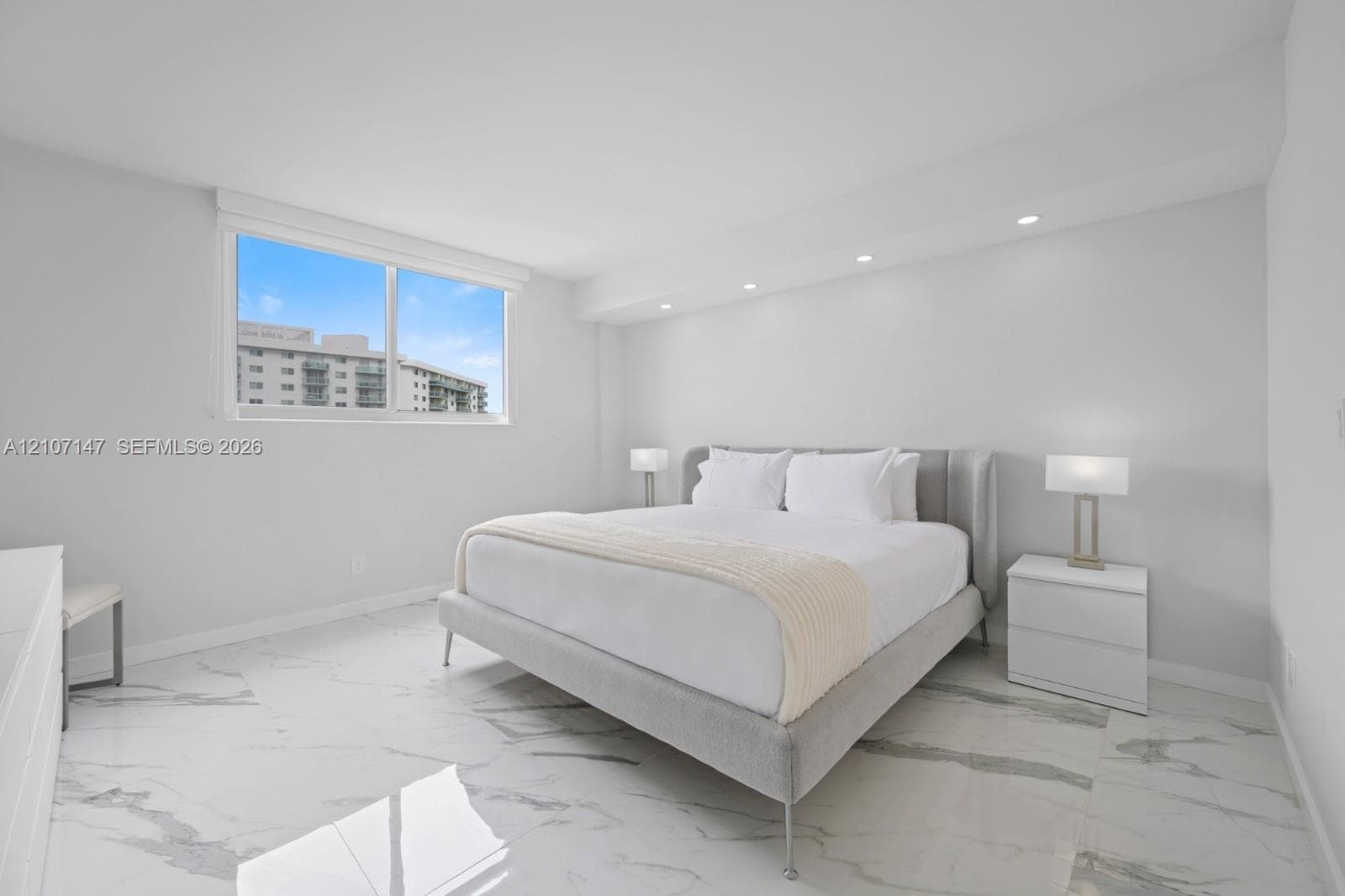Polished stone flooring, recessed ceiling lighting, and a large window