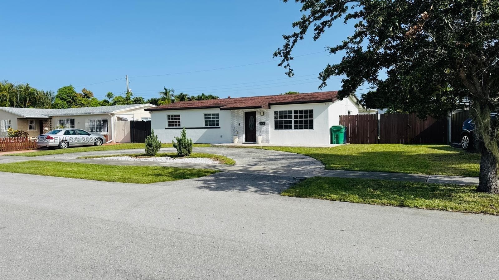 Rear yard featuring a concrete patio, a covered lanai with structural support columns, and full-perimeter wood fencing