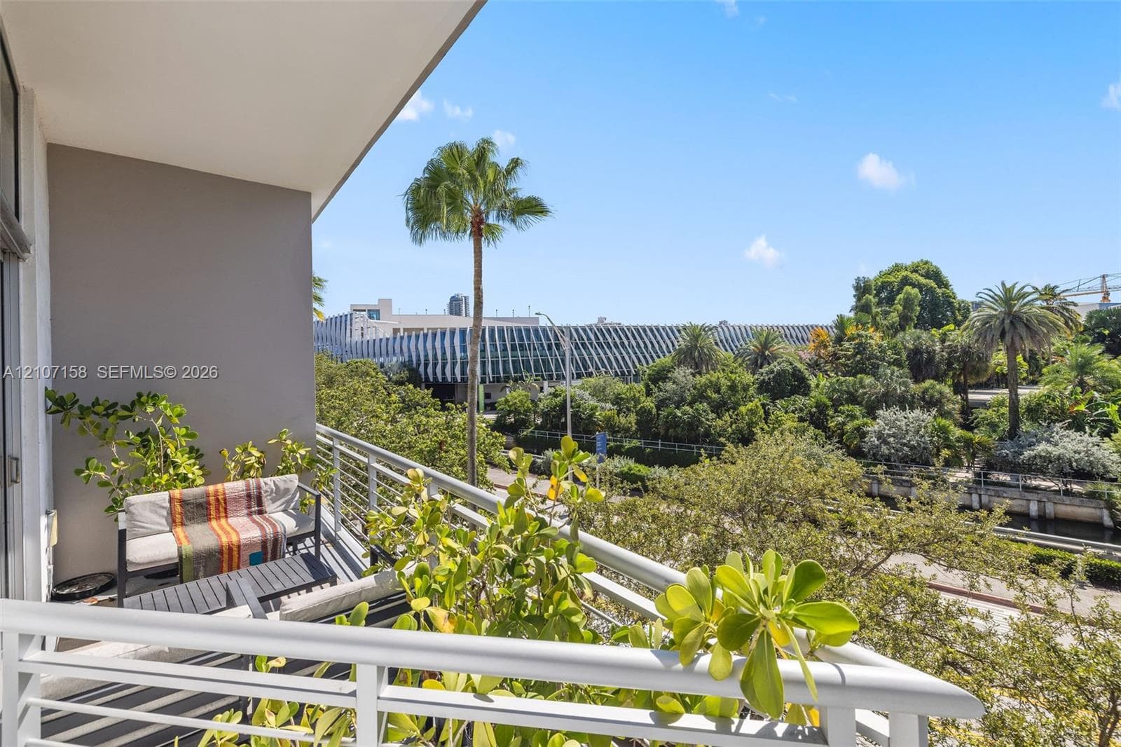 Covered private balcony featuring a horizontal metal railing and concrete flooring