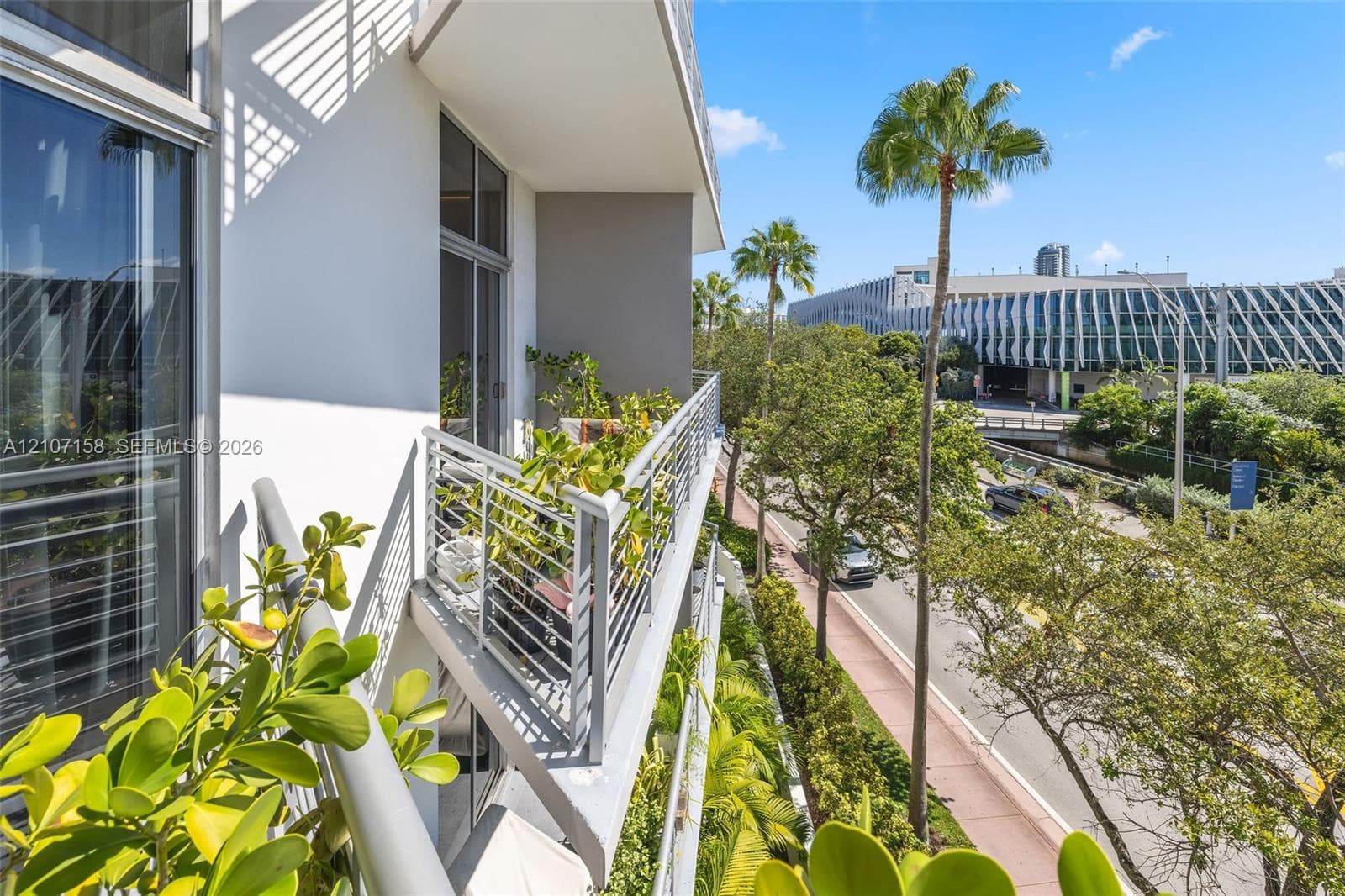 Private balcony featuring metal railings and floor-to-ceiling glass sliding doors