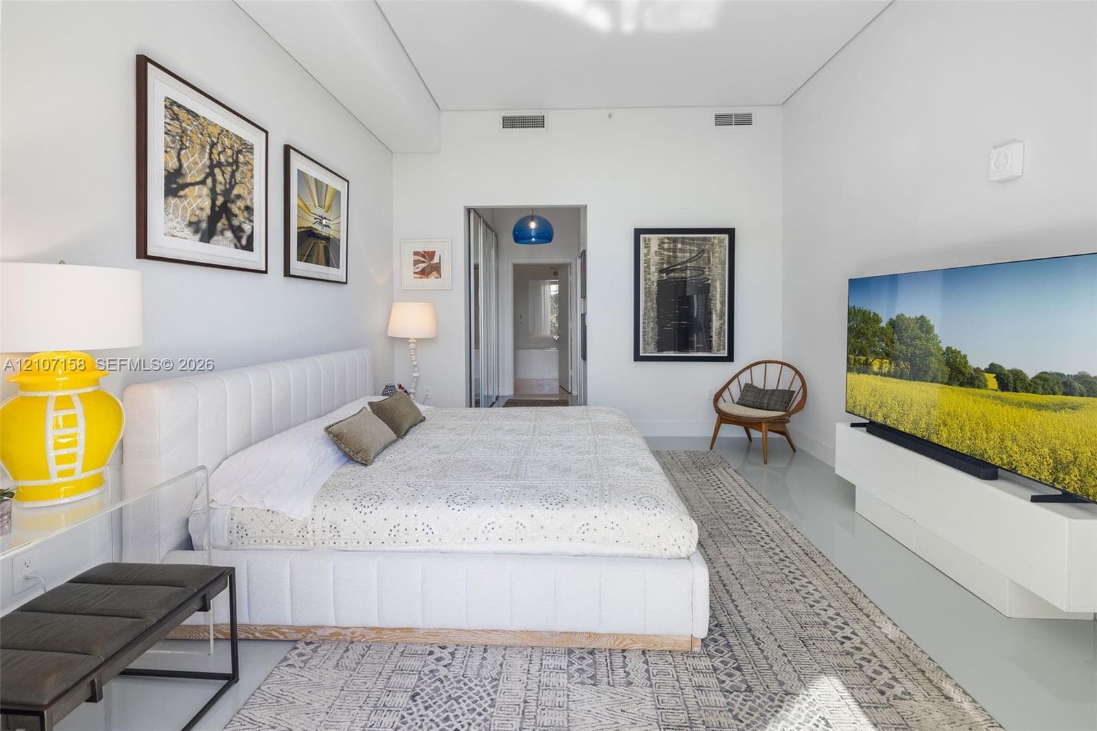 High-ceilinged room featuring smooth-finish light flooring and a white floating wall-mounted console