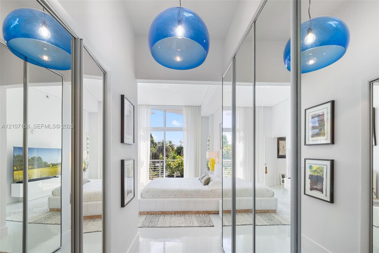 Full-height mirrored sliding wardrobe doors, polished flooring, and prominent spherical pendant lighting