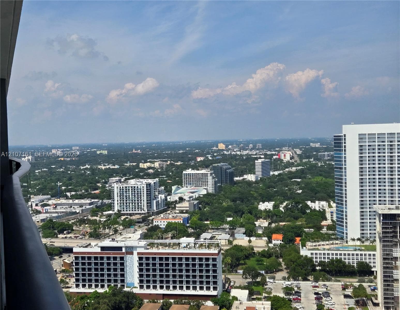 High-rise balcony featuring metal railing and expansive cityscape outlook