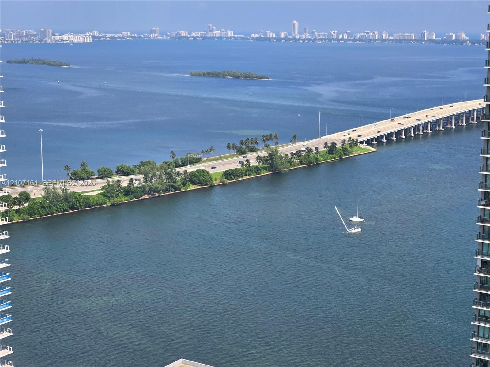 Elevated perspective featuring expansive water frontage, a causeway, and a skyline horizon
