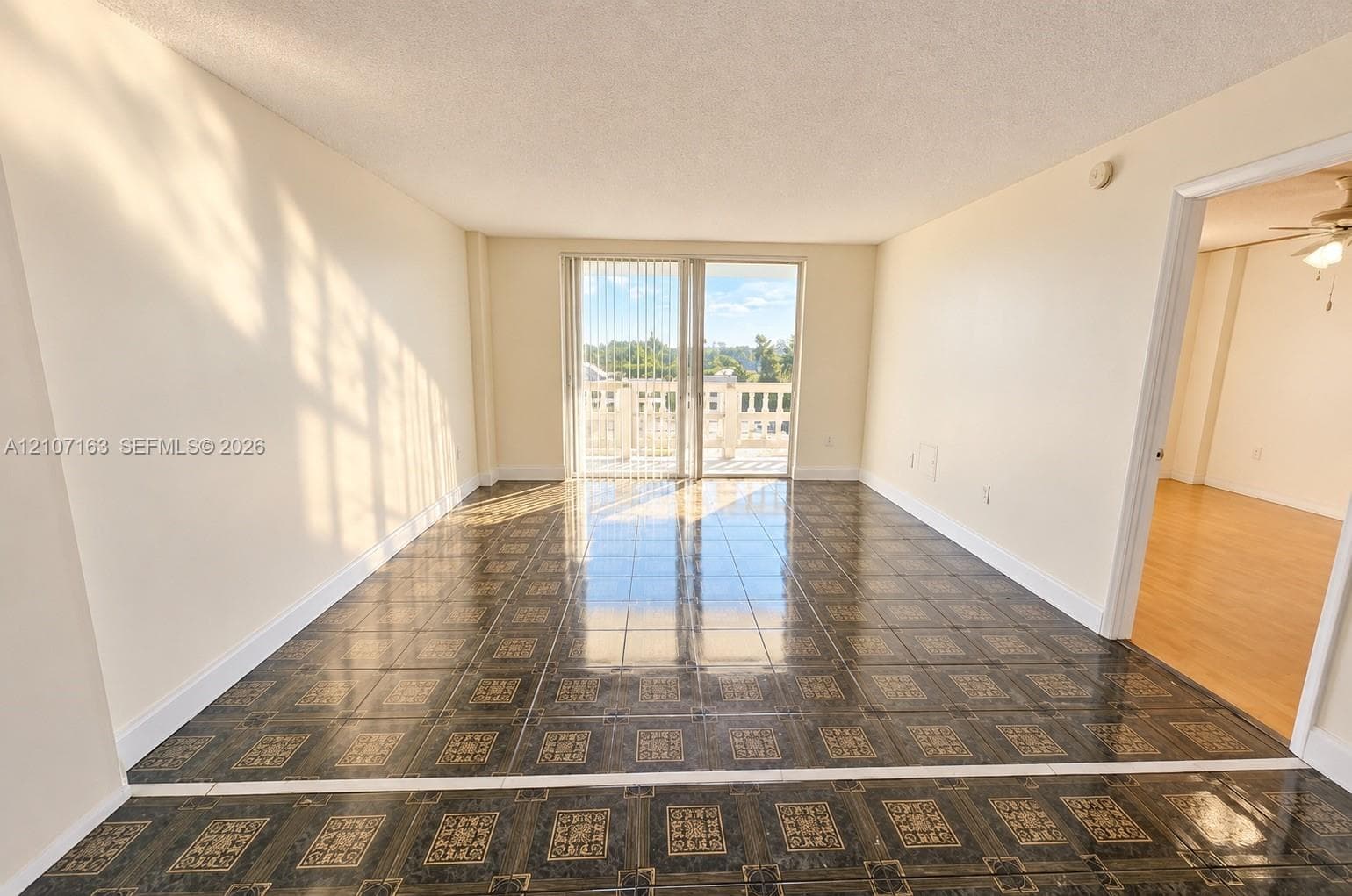 Interior space featuring patterned tile flooring and sliding glass doors leading to an exterior balcony