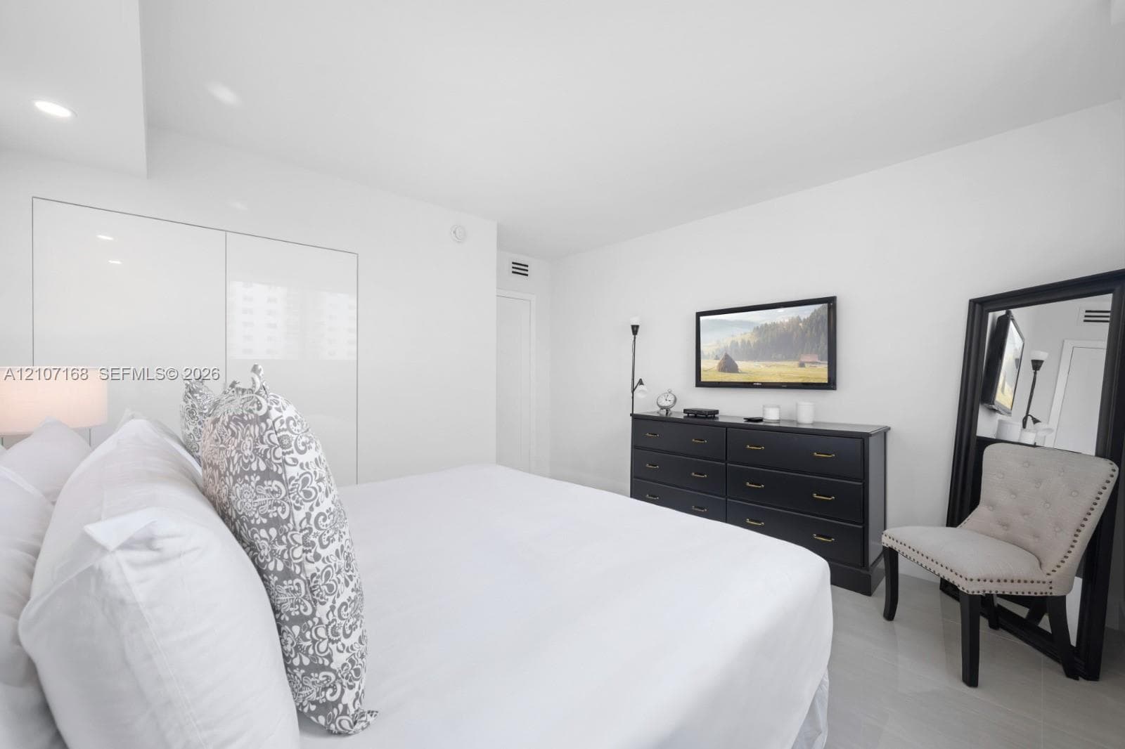 Interior space featuring recessed lighting, high-gloss floor-to-ceiling built-in cabinetry, and neutral tile flooring
