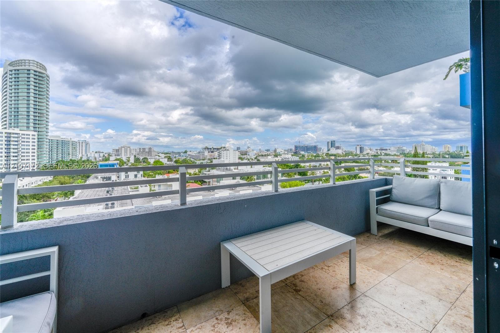 Covered balcony featuring tile flooring and horizontal metal railing