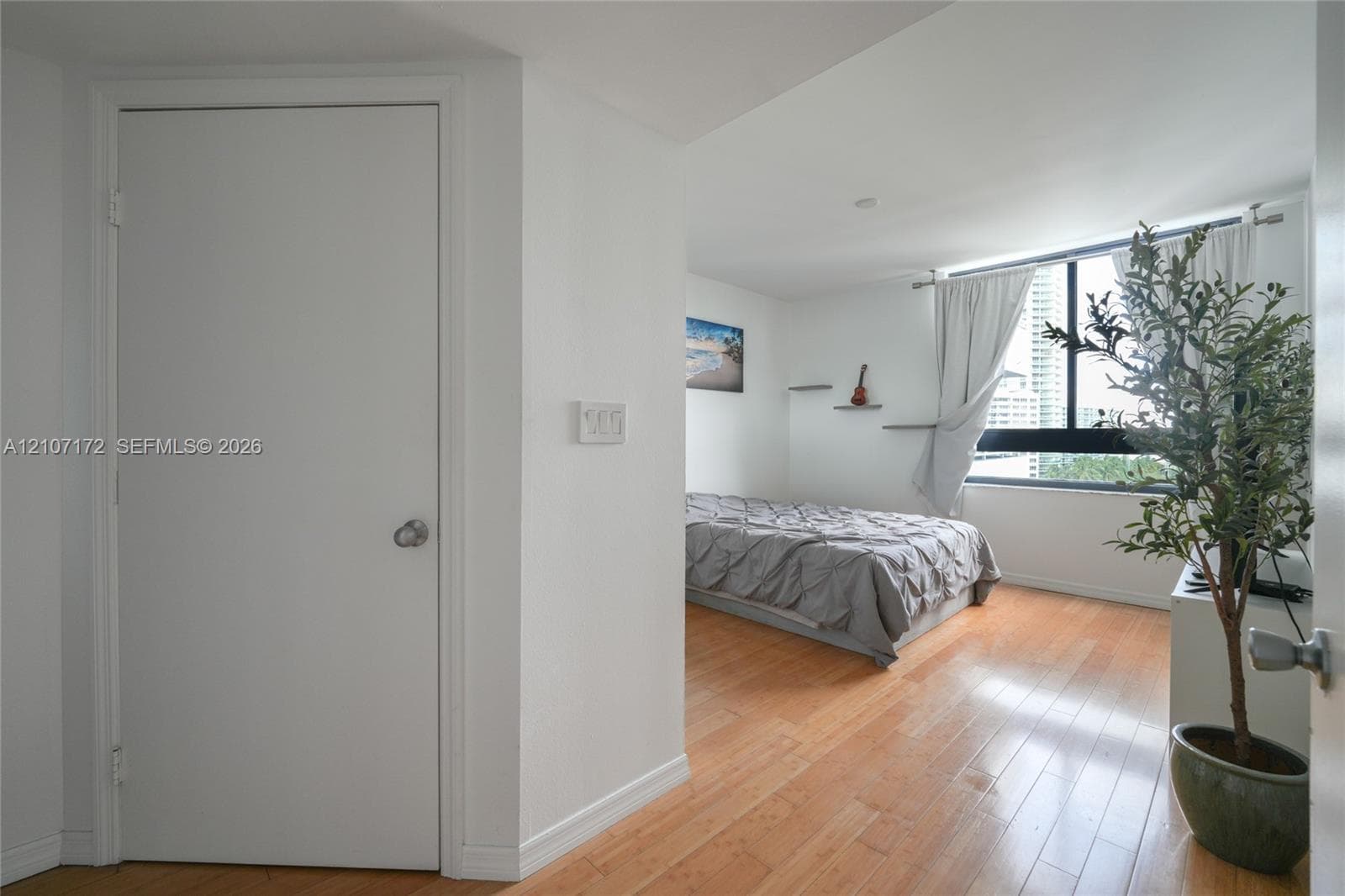 Wood-finish flooring and large window with exterior urban scenery