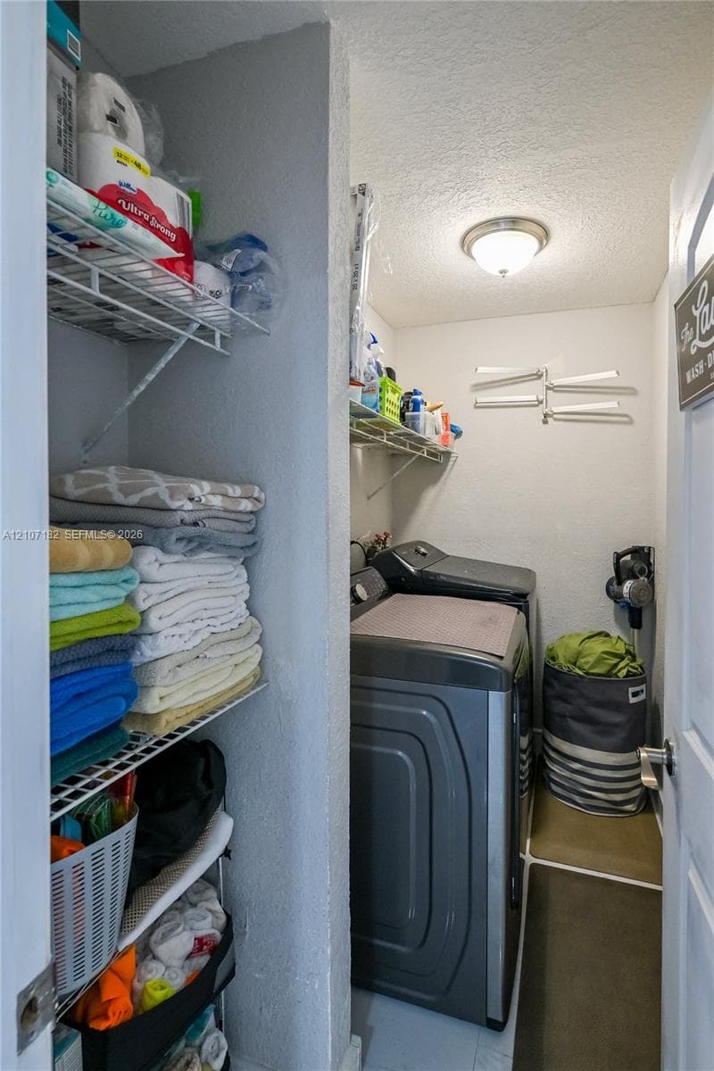 Laundry space featuring built-in wire shelving and a flush-mount ceiling light fixture