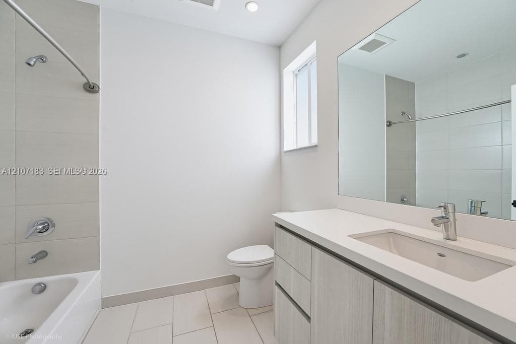 Modern vanity featuring a light-toned wood-finish cabinet and integrated solid-surface countertop with an undermount basin