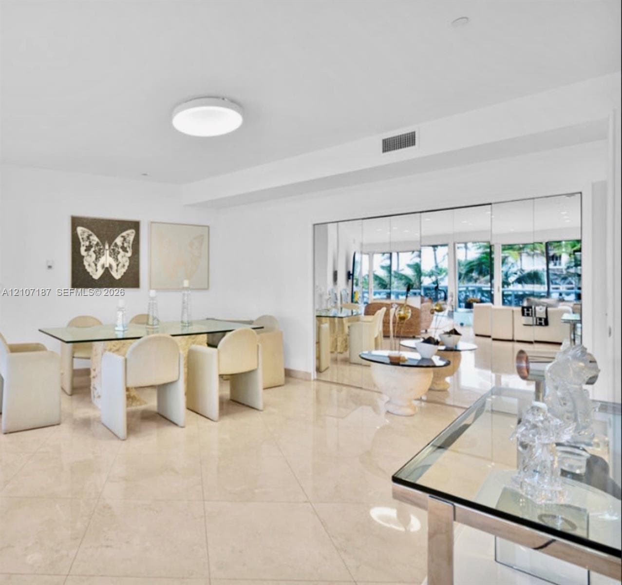 Large-format stone tile flooring, expansive floor-to-ceiling mirrored walls, and recessed ceiling lighting