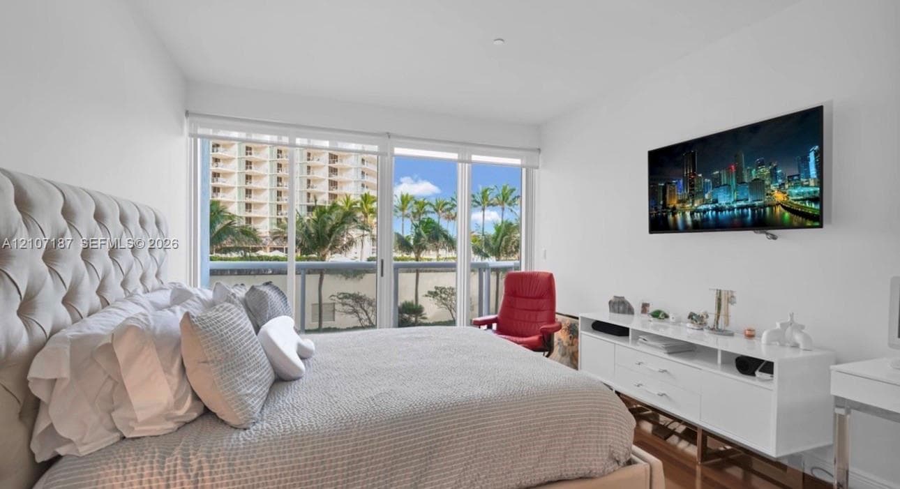 Floor-to-ceiling sliding glass doors with roller shades and wood-finish flooring