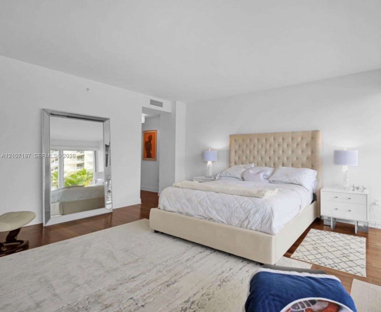Bedroom featuring wood-finish flooring, smooth-finish ceilings, and expansive glass paneled window