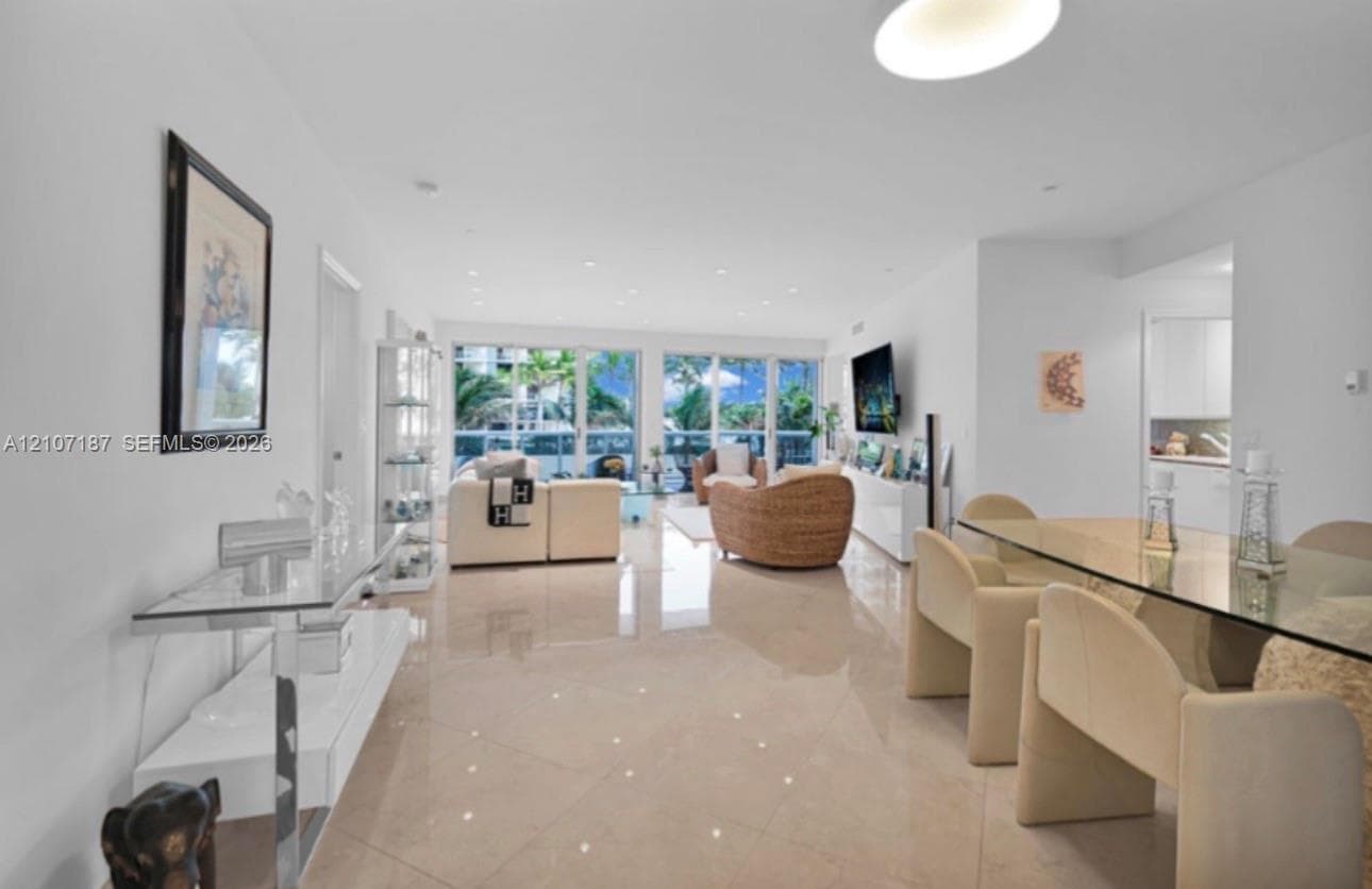 Open-concept interior featuring large-format polished tile flooring, recessed ceiling lighting, and floor-to-ceiling glass sliding doors