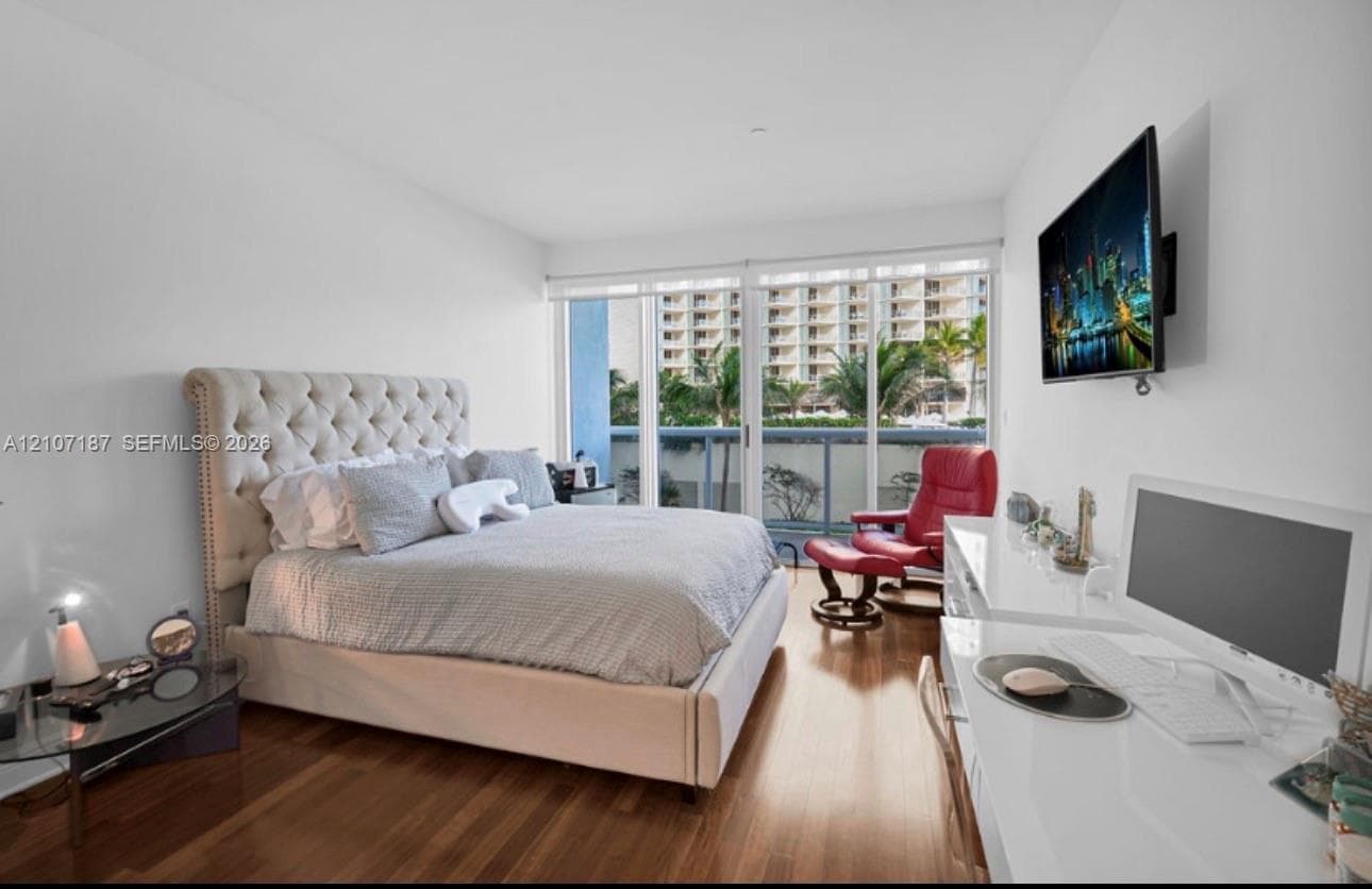 Floor-to-ceiling sliding glass doors, wood-finish flooring, and recessed ceiling lighting