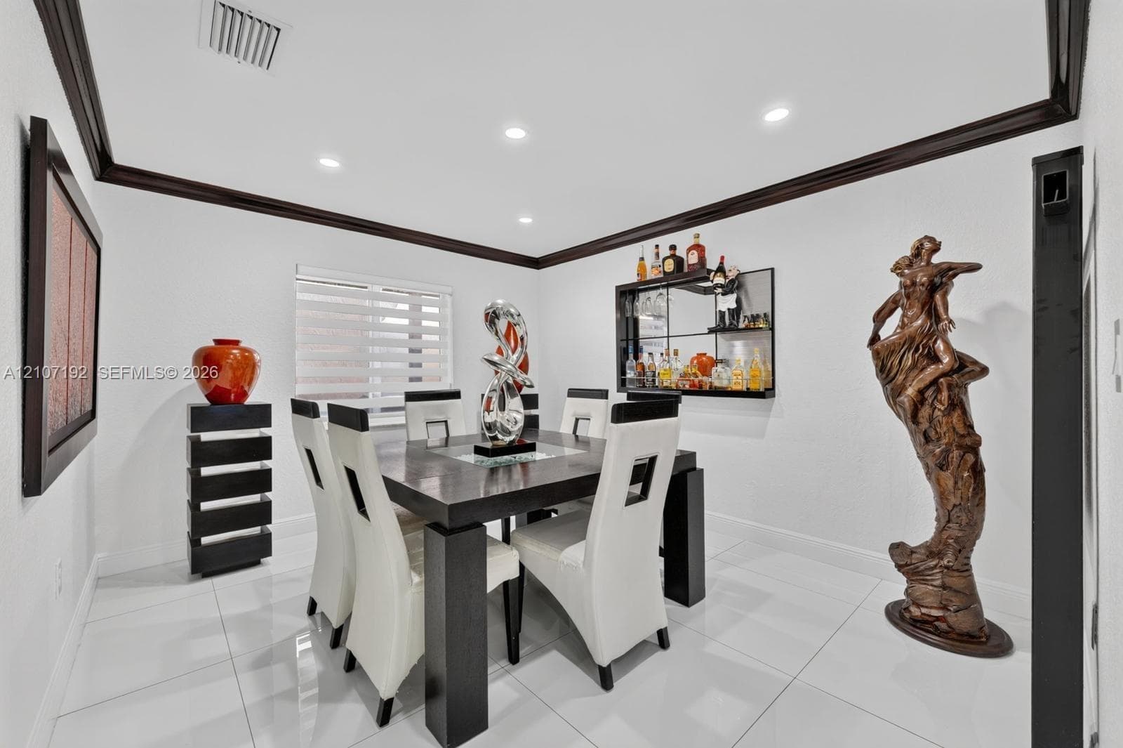 Large-format tile flooring, crown molding, recessed lighting, and built-in mirrored shelving