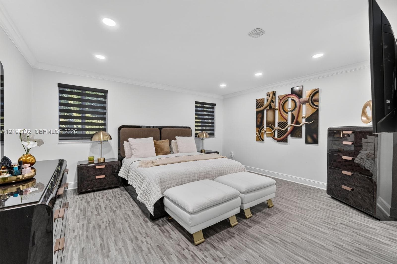 Room featuring wood-finish flooring, recessed lighting, and dual windows with modern retractable shades